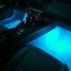 the interior of a car is lit up with blue light and red lights on it