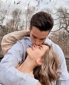 a man and woman kissing each other while sitting on a bench