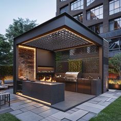 an outdoor kitchen is lit up at night with lights on the grill and seating area