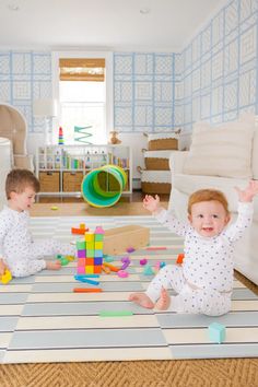 two babies playing with blocks on the floor