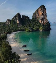 several boats are parked on the beach near an island