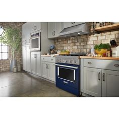 a kitchen with white cabinets and blue oven