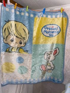 a child's blanket hanging on a clothesline with an image of a boy