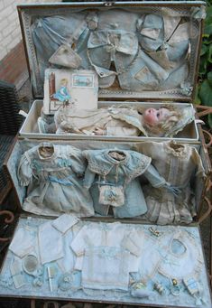 an open suitcase filled with baby clothes on top of a table