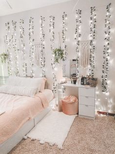 a bedroom decorated with white lights and pink bedding