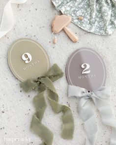 two month old baby's first birthday badges on a white tablecloth with ribbons