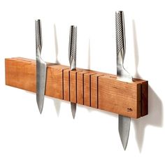 five knives are hanging on a wall mounted knife holder