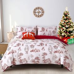 a bed covered in red and white comforters next to a christmas tree