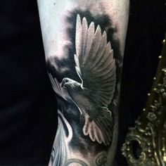 a black and white bird tattoo on the arm