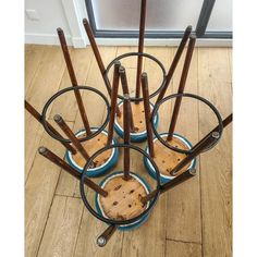 a set of four wooden and metal stools with wheels on the bottom, in front of a door