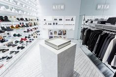 the inside of a clothing store with shoes on display