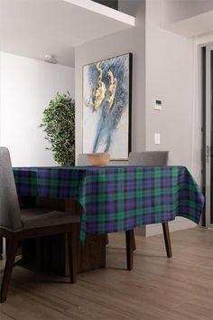 a dining room table with a blue and green plaid table cloth on top of it