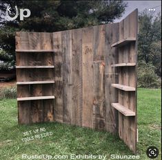 a wooden bookcase sitting on top of a lush green field