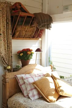 a bed with lots of pillows on top of it next to a wall mounted shelf