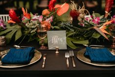 a table set with place settings and flowers