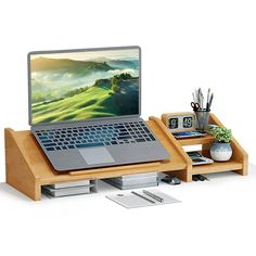 an open laptop computer sitting on top of a wooden desk next to a drawer filled with pens and pencils