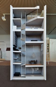 a model of a book shelf with shelves and ladders on each side, in the shape of a house