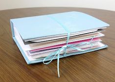 a stack of papers tied up on top of each other with a blue ribbon around them