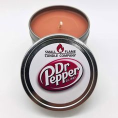 a small tin of lip bale sitting on top of a white table next to a candle