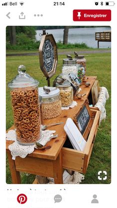 the table is full of food and drinks for an outdoor party or gathering in the park