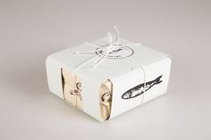 a white box wrapped in brown paper and tied with twine