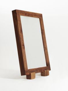 a wooden stand with a mirror on it's sides and two legs in the middle