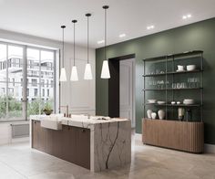 a kitchen with green walls and marble counter tops in front of an open floor plan