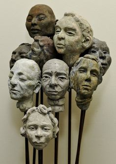 a bunch of heads that are on some sticks