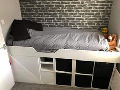 there is a bed that has been built into the side of a wall with shelves underneath it