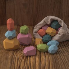 colorful wooden blocks are scattered around a bag