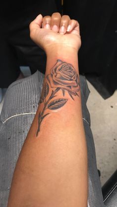 a person with a rose tattoo on their arm