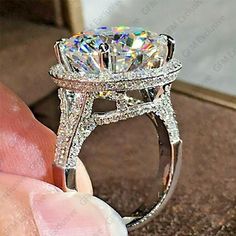 someone is holding an engagement ring with a large diamond in it's middle finger