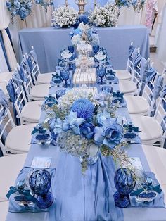 a long table with blue and white flowers on it is set up for an event