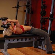 a woman is doing exercises on a bench with a dumbbell in a gym room