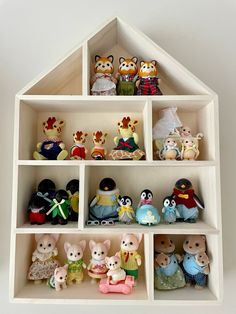 a doll house shelf filled with lots of small toy figurines on top of it