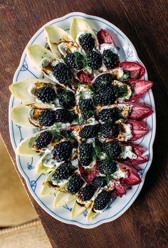 a white plate topped with fruit and veggies on top of a wooden table