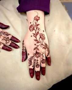 a woman's hand with henna tattoos on it