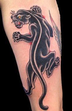 a black panther tattoo on the left arm and leg, with an arrow in its mouth