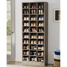 a large shoe rack with many pairs of shoes on it in a room next to a door