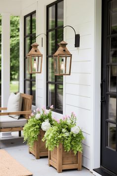 two wooden planters with flowers on the front porch