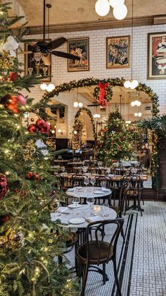 a decorated christmas tree in the middle of a restaurant with tables and chairs set up