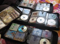 there are many cd's in the suitcases on the bed