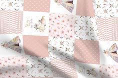 a pink and white patchwork quilt with teepees