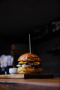 a hamburger sitting on top of a wooden cutting board