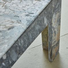 a marble bench sitting on top of a cement floor