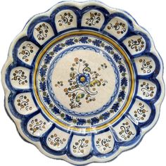 a blue and white plate with an ornate design on the center, surrounded by small flowers