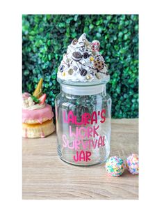 a glass jar filled with lots of sprinkles on top of a wooden table