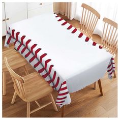 a dining room table covered with red and white striped baseballs on the tablecloth