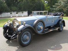 an old blue car is parked on the street