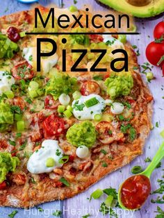 a mexican pizza with tomatoes, avocado and sour cream on it is shown